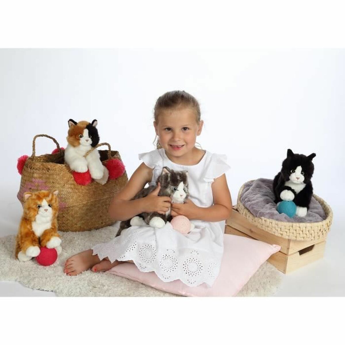 Petite fille avec plein de peluche chat réaliste de multiples couleurs