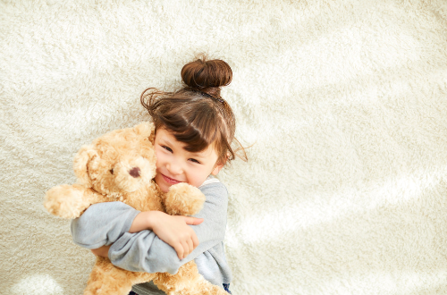 petite fille avec son ourson couleur caramel