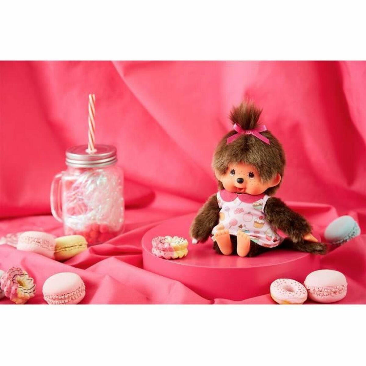 kiki singe peluche assis sur un support rose
