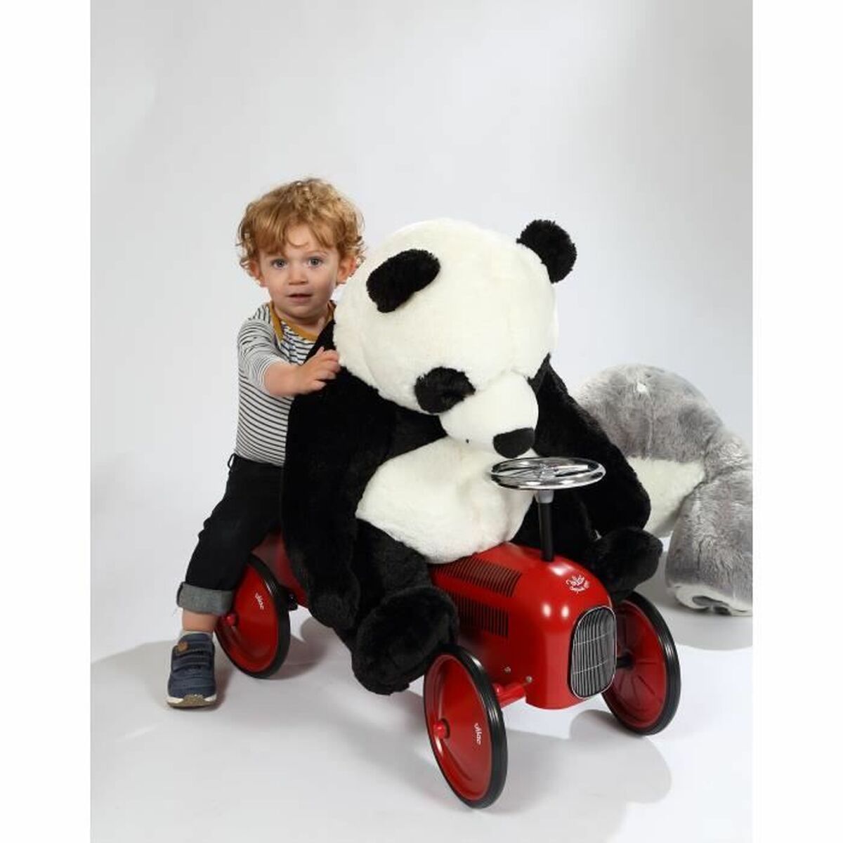 petit garçon qui joue avec un panda en peluche géant