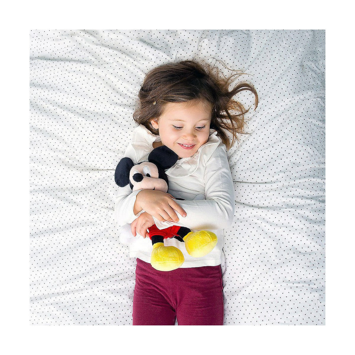 petite fille qui tient sa peluche disney mickey