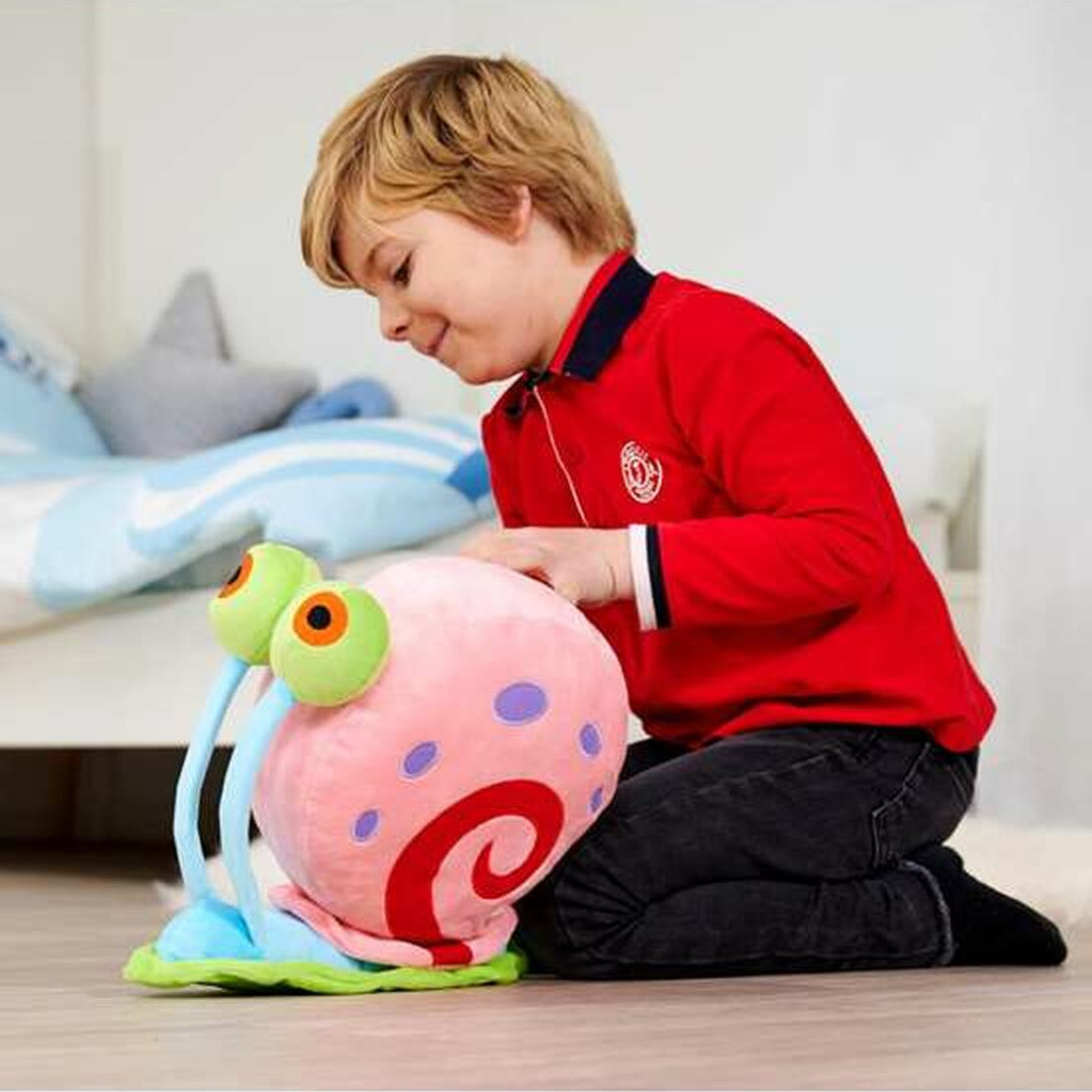 enfant qui joue avec la peluche gary de bob l'éponge