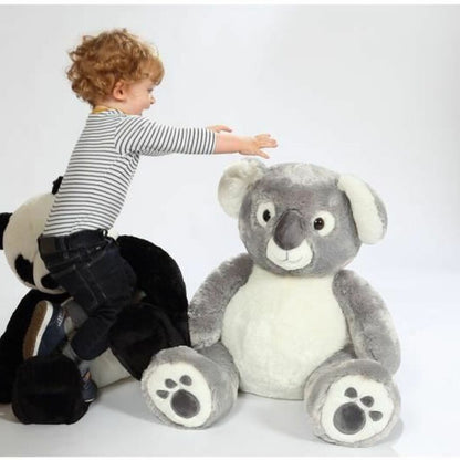 Peluche koala grise avec un petit garçon qui veut l'attraper