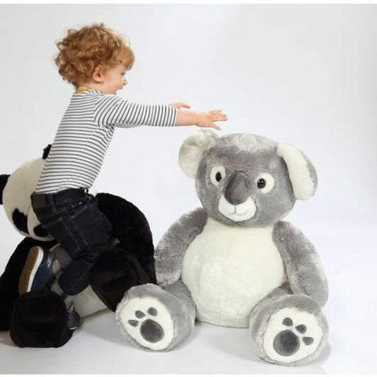 Peluche koala grise avec un petit garçon qui veut l'attraper