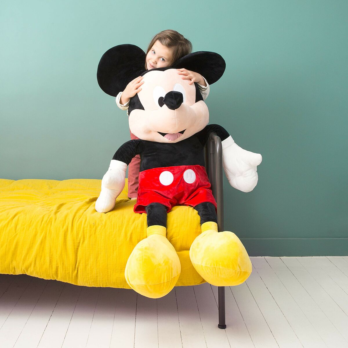 petite fille qui fait un calin à la peluche mickey de 120cm