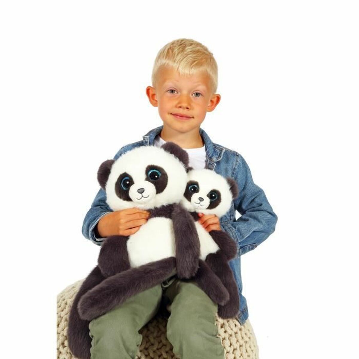 un petit garçon qui portent deux peluches panda