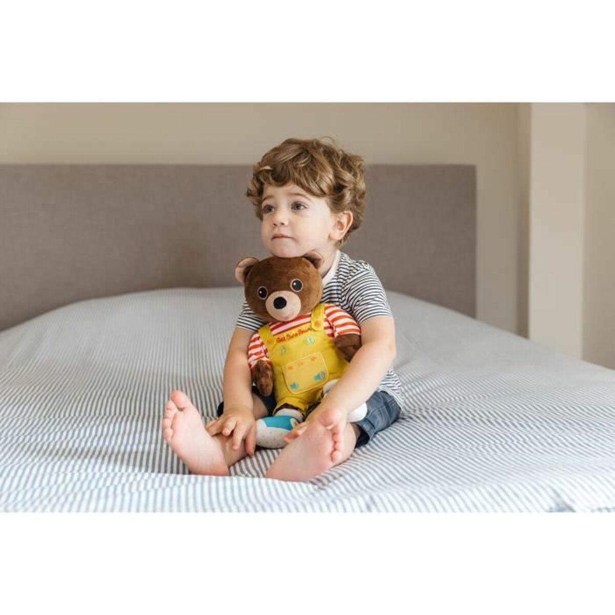 petit garçon avec sa peluche petit ours brun dans ses bras