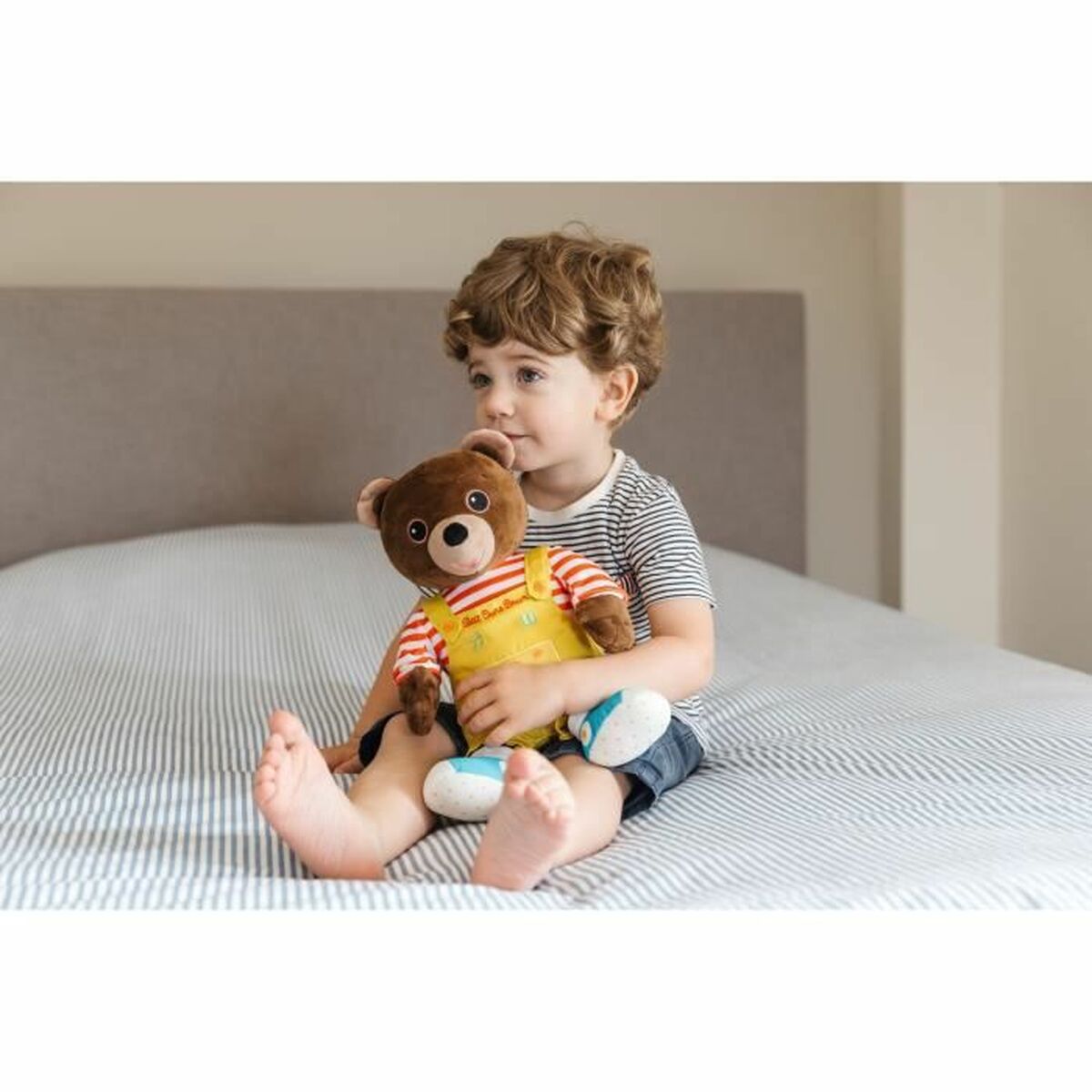 peluche petit ours brun dans un lit